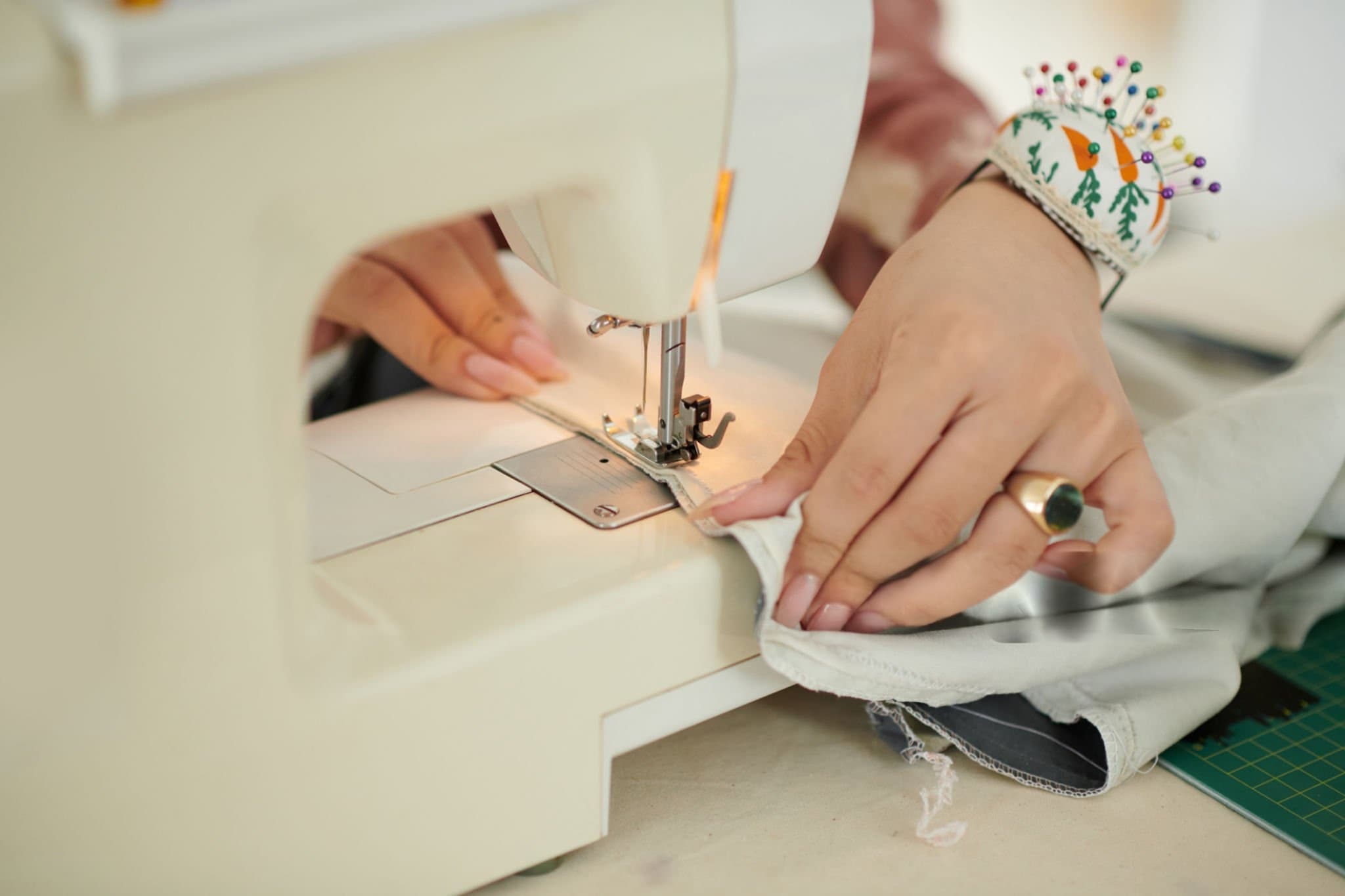 A background image showing a tailor's workshop with fabrics and a sewing machine.